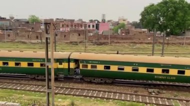 Yolcu dolu tren 14 Nisan 2024 'te Pakistan' ın Lahor kentindeki eski bir raydan geçiyor.