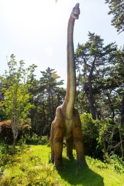 Dinozor heykelleri olan bir orman parkı manzarası