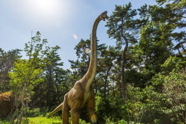 Dinozor heykelleri olan bir orman parkı manzarası