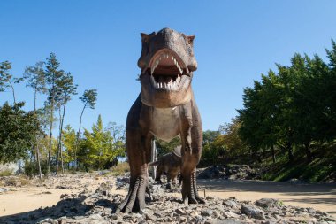 Dinozor heykelleri olan bir orman parkı manzarası