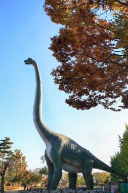 Dinozor heykelleri olan bir orman parkı manzarası