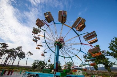 Mavi gökyüzü arka planda eğlence parkının renkli dönme dolap.