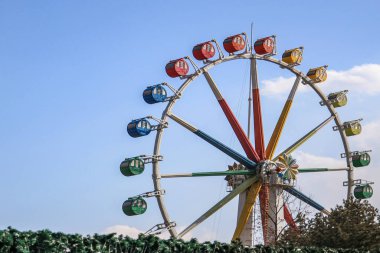 Mavi gökyüzü arka planda eğlence parkının renkli dönme dolap.