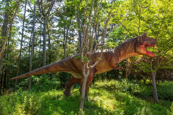 Dinozor heykelleri olan bir orman parkı manzarası