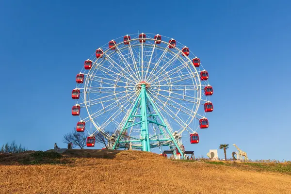 Mavi gökyüzü arka planda eğlence parkının renkli dönme dolap.