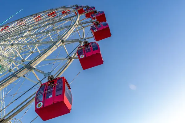 Mavi gökyüzü arka planda eğlence parkının renkli dönme dolap.