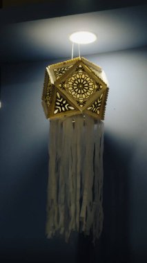 Sarı ve beyaz renkli zarif ve güzel aydınlatılmış Vesak fener (Vesak Kuduwa), geleneksel olarak karmaşık desenler ve akışkan kağıt şeritlerle işlenmiş. Sri Lanka kültür şenlikleri ve dini kutlamalarla ilgili içerik için mükemmel.
