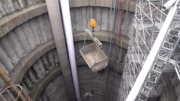 在起重机的帮助下 从地铁隧道竖井中降低了挖掘桶 — 图库视频影像