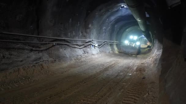 建設作業員は 地下トンネル建設中にニューオーストリアのトンネル法で作られたトンネル内の建設車両を運転します — ストック動画