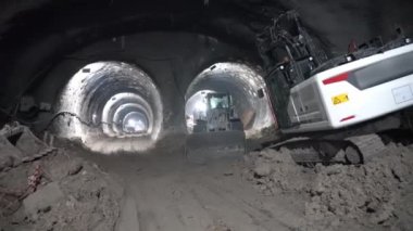 Kazıcılar ve buldozerler iki yeraltı metro tünelinde çalışır.