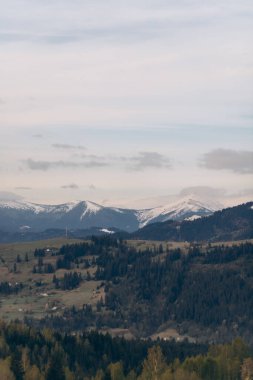Dağlar karla kaplı ve gökyüzü bulutlu. Huzurlu ve huzurlu bir sahne.