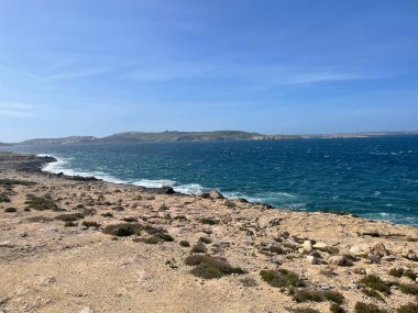 Uzakta bir adaya uzanan kum, kaya ve okyanusla dolu güzel bir sahil ufku. Doğanın güzelliği tam gösterimde.!