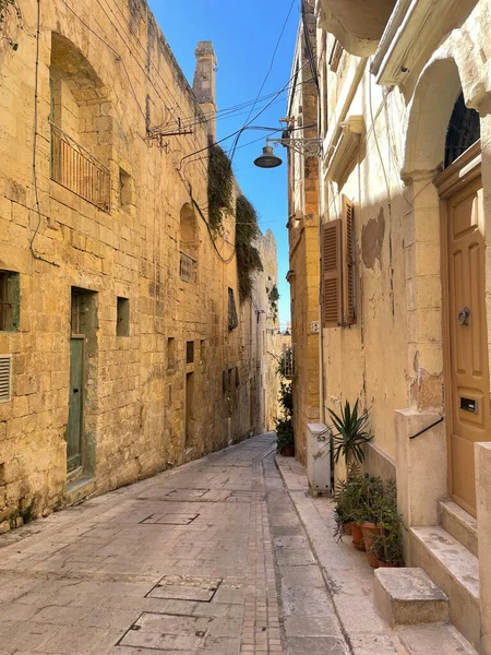Historic village alley with ancient architecture and charming Maltese buildings.