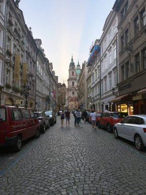 Prag 'da kaldırım taşı ve araçları olan bir şehir caddesi..