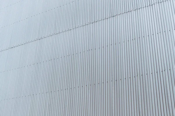 Dikey Çizgileri Olan Beyaz Metalik Kıvrımlı Bina Cephesinin Dokusunun Perspektif — Stok fotoğraf