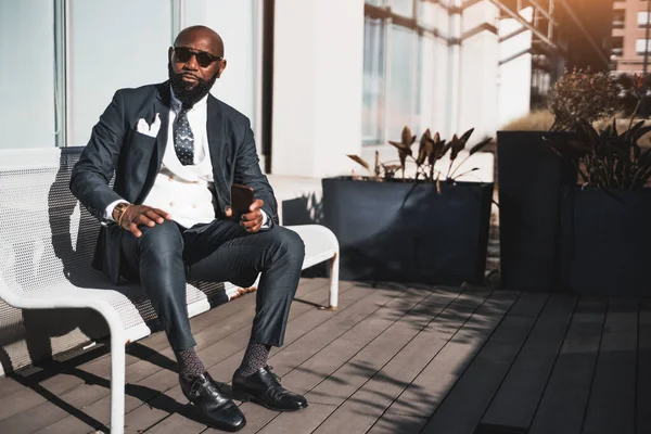 Stylish Bald Businessman Exudes Confidence Sits Sleek White Metal Bench — 图库照片