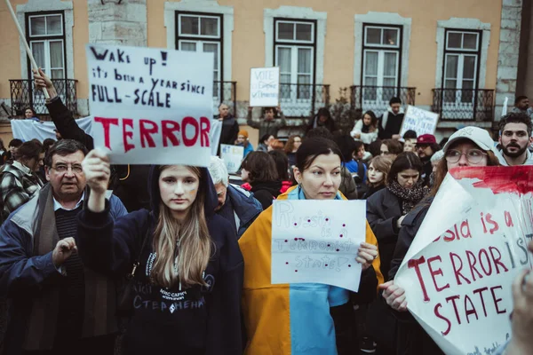 ポルトガルのリスボン 2023年2月24日 ウクライナでの紛争の1周年を記念する抗議の最前列で 焦点を当てたいくつかの女性は強力な反戦メッセージを持つ段ボールを保持しています — ストック写真
