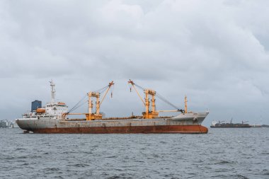 Sakin denizlerdeki bir kargo gemisi, deniz erozyonu belirtileri gösteriyor, şehir limanına hayati erzaklar taşıyor. Dalgalar gövdesine çarpar, ama yolculuk devam etmeli.