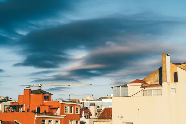 Błękitne Niebo Dostrzeganymi Ciemnymi Chmurami Dużym Jasnopomarańczowym Domem Wyróżnia Się — Zdjęcie stockowe