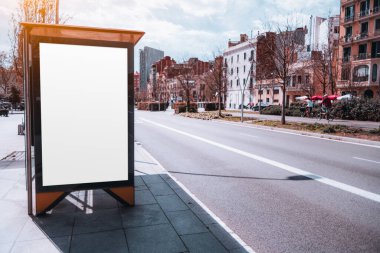 Barselona 'da, güzel güneşli bir gün için pitoresk bir mahalle arka plandır. Beyaz, boş bir maket ya da reklam panosu otobüs durağında belirgin bir şekilde duruyor, temiz ve temiz bir estetik yaratıyor.