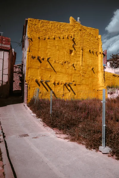 在西班牙的Caldes Montbui 一座被风吹日晒的老住宅建筑装饰着生机勃勃 明亮的黄色涂料 其质感很奇怪 这种颜色向周围环境中流露出一种活生生的感觉 — 图库照片