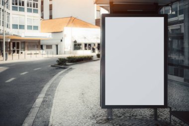 Empty urban street with a modern bus stop shelter, featuring a large blank advertising billboard. The quiet cobblestone sidewalk and contemporary buildings create a serene cityscape clipart