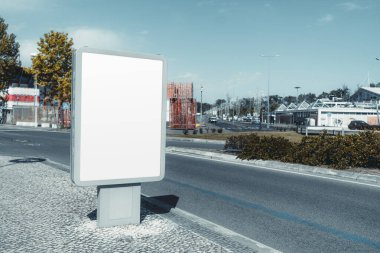 Empty urban billboard mockup on a modern city street. Blank advertising space in a sleek metal frame, standing on a cobblestone sidewalk with road, trees, and buildings in the background clipart