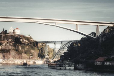 Porto, Portekiz 'deki Douro Nehri' ne uzanan Ponte do Infante köprüsünün modern mimari görüntüsü, tarihi çelik bir köprü ve arka planda manzaralı bir yamaçla