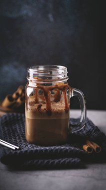 Mavi havlunun üzerinde bir kaşık ve kaşıkla bir kavanoz kahve.