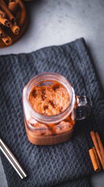 Bir kavanoz soğuk kahve tereyağı tarçın çubuklu peçetenin üzerinde