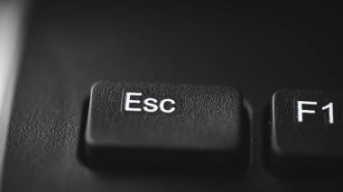 Bir bilgisayar klavyesindeki Esc (Kaçış) tuşuna yakın çekim, alanın sığ derinliği