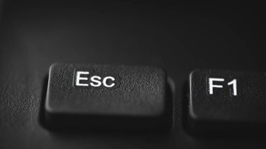 Bir bilgisayar klavyesindeki Esc (Kaçış) tuşuna yakın çekim, alanın sığ derinliği