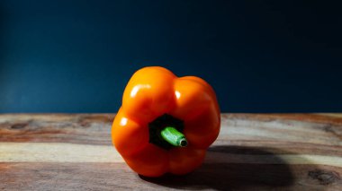 Tahta bir yüzeyde taze olgun portakal biberleri.