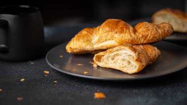 Siyah kahve fincanlı kruvasan.