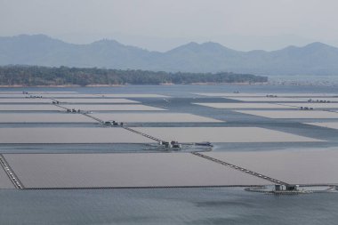 Waduk Cirata gölündeki yüzen güneş panelleri ya da güneş pili platformu sisteminin havadan görüntüsü. Suyu olan enerji santrali, yenilenebilir enerji kaynağı. Sanayide elektrik enerjisi için eko teknoloji.