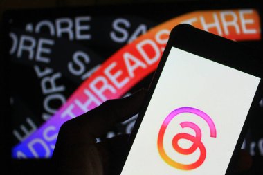 28 Ekim 2024 - Bandung, Endonezya: Bu fotoğraf illüstrasyonunda, arka planda akıllı telefon ve Meta logosu üzerinde görülen iplikler.