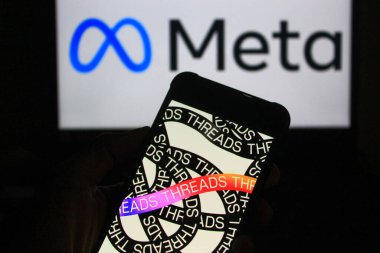 28 Ekim 2024 - Bandung, Endonezya: Bu fotoğraf illüstrasyonunda, arka planda akıllı telefon ve Meta logosu üzerinde görülen iplikler.