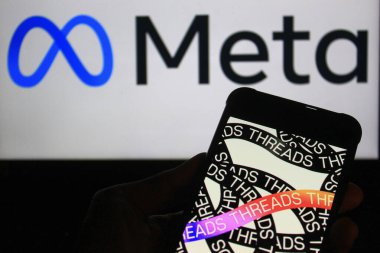 28 Ekim 2024 - Bandung, Endonezya: Bu fotoğraf illüstrasyonunda, arka planda akıllı telefon ve Meta logosu üzerinde görülen iplikler.