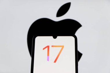 Bandung, Endonezya - 27 Ağustos 2025: Bu resimde Ios 17 Iphone logosu arka planda Apple logosu olan bir akıllı telefonda sergileniyor. 