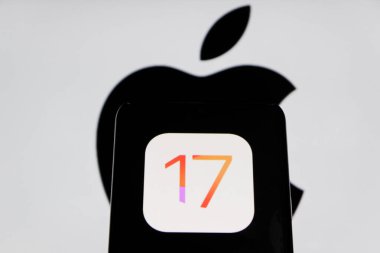 Bandung, Endonezya - 27 Ağustos 2025: Bu resimde Ios 17 Iphone logosu arka planda Apple logosu olan bir akıllı telefonda sergileniyor. 