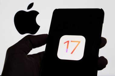Bandung, Endonezya - 27 Ağustos 2025: Bu resimde Ios 17 Iphone logosu arka planda Apple logosu olan bir akıllı telefonda sergileniyor. 