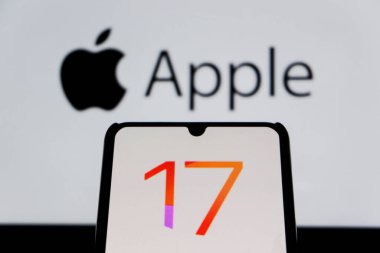 Bandung, Endonezya - 27 Ağustos 2025: Bu resimde Ios 17 Iphone logosu arka planda Apple logosu olan bir akıllı telefonda sergileniyor. 