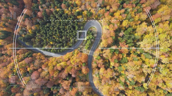 Smart car for intelligent self driving on winding road through the autumn forest. Futuristic HUD display elements satellite car surveillance and identification monitoring target vehicle