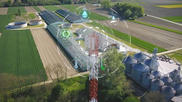 Climate change ecological green symbols revolve around transmission mast in front of natural agricultural production.Solar energy, water, temperature, plant