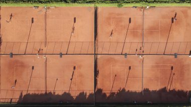 Oyuncular ve gölgeli tenis eğitim kamplarının yukarıdan aşağı görüntüsü