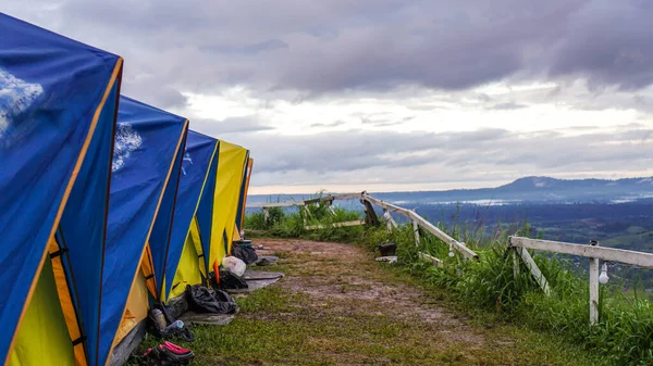 Tourist tent with the spectacular view of Khao Kho, Phetchabun Province in Thailand. Tent in camping with flog and mountain view. Tent on campsite by the hill in rainy day.