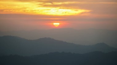 Akşam sisli gökyüzünde güneş ve şehvetli güneş ışığı. Tayland dağının panoramik huzurlu manzarası. İklim, çevre ve seyahat konsepti.