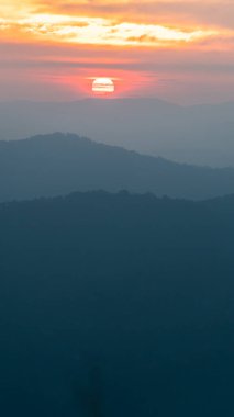 Akşam sisli gökyüzünde güneş ve şehvetli güneş ışığı. Tayland dağının panoramik huzurlu manzarası. İklim, çevre ve seyahat konsepti.