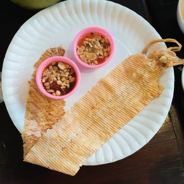 Tayland usulü acı biberli kurutulmuş ızgara ve ezilmiş kalamar. Beyaz kağıt tabakta tatlı soslu ezilmiş mürekkep balığı..