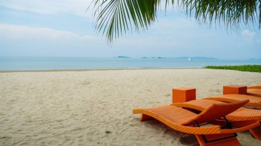 Kumsalda ve mavi gökyüzünde branda sandalye. Tayland 'ın Rayoung bölgesindeki plaj tuvalleri. Kanvas katlanır yatak Sahilde parlak bir gökyüzünde